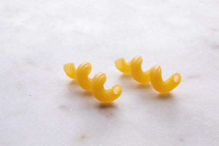 Close up of uncooked pasta on white marble background with copy spaceの写真素材