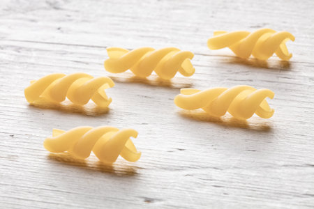 Uncooked italian pasta on white wooden background. close up.の写真素材