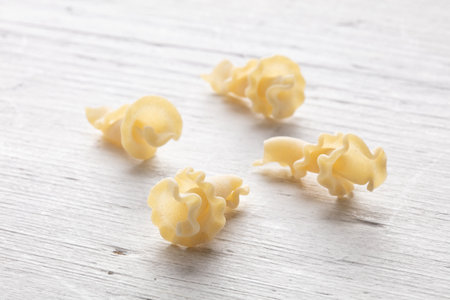 Uncooked italian pasta on white wooden table, closeup viewの写真素材