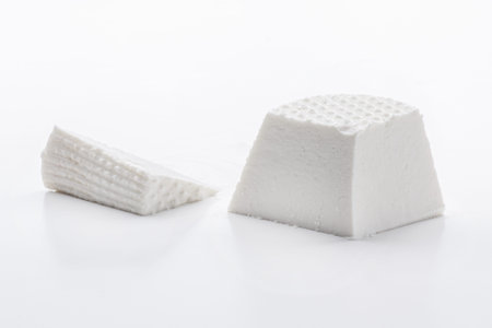 piece of fresh white soft cheese made from cow milk isolated on white background