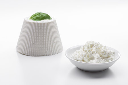 Cottage cheese and basil on a white background, close-upの写真素材