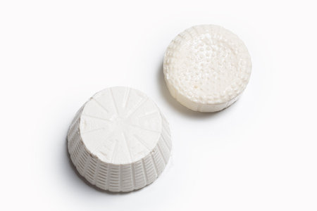 White round cheese on a white background. Top view. Close up. Isolated.の写真素材