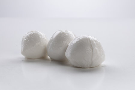 Fresh mozzarella cheese balls on a white background with reflection.の写真素材