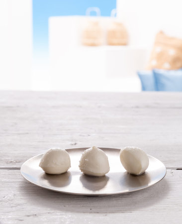 mozzarella bites on silver plate with white rustic wood background
