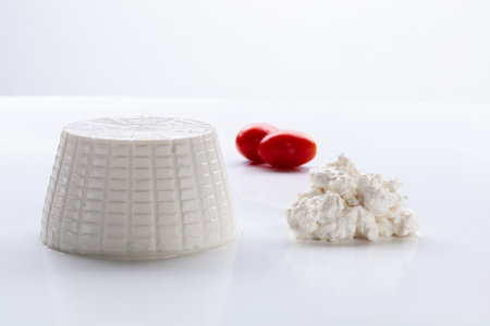 whole and crumbled ricotta with red cherry tomatoesの写真素材