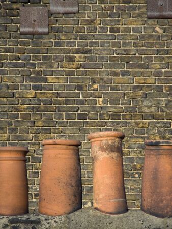 Terracotta Chimney Pots on Roof with brick wall の写真素材