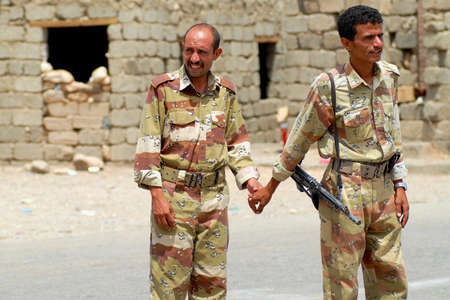 Hadramaut Valley, Yemen, September 10, 2006 - Yemeni military men hold hands at the security checkpoint, Hadramaut valley, Yemen. Tourism in Yemen is dangerous now because of kidnappings.のeditorial素材