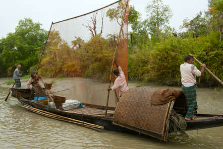 Mongla, Bangladesh, February 17, 2014 - Men do fishing with otters in Mongla, Bangladesh.のeditorial素材