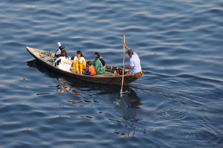 Dhaka, Bangladesh, February 21, 2014 - Residents of Dhaka cross Buriganga river by boat in Dhaka, Bangladesh. Thousands of people in one of the most populated capitals of the world use ferry boats daily on the way to work and back home.のeditorial素材