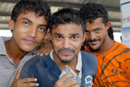 Al Hudaydah, Yemen, September, 2006 - Fishermen drink water from transparent plastic bag in Al Hudaydah, Yemen. Clean drinking water in plastic bags is the best cheap option available for locals at fish market in Al Hudaydah.のeditorial素材
