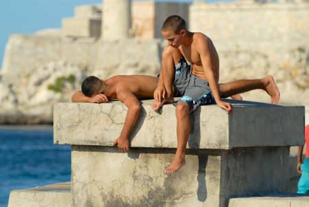Havana, Cuba, October 21, 2006 - Young men sunbathe at the Malecon seawall in Havana, Cuba.のeditorial素材