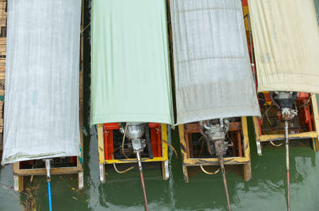 Colorful long-tail boats tied under the rain in Suphan Buri, Thailand.の写真素材