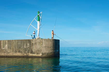 Ravine Saint-Gilles De Reunion, France, December 08, 2010 - Men do fishing from the pier in Ravine Saint-Gilles De Reunion, France.のeditorial素材