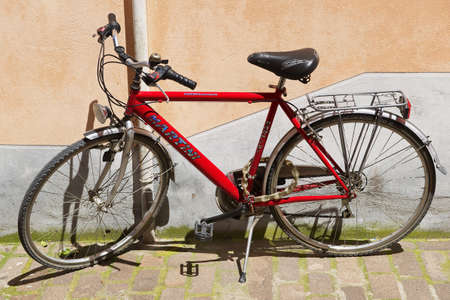 Rimini, Italy - May 13, 2013: Red bicycle parked in front of the pink wall in Rimini, Italy.のeditorial素材