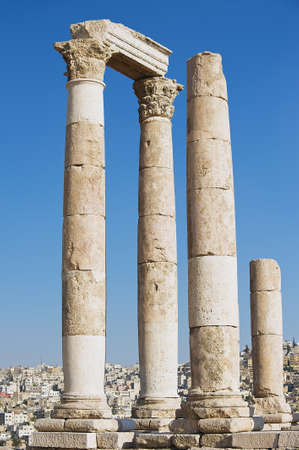 View to the ancient stone columns at the Citadel of Amman with the Amman city at the background in Amman, Jordan.の写真素材