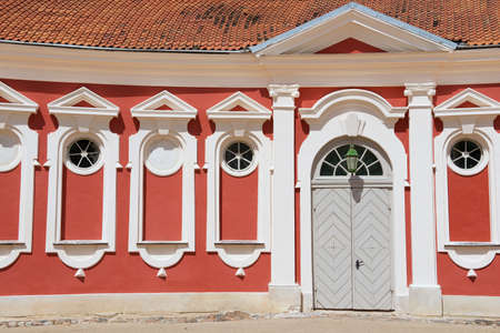 Pilsrundale, Latvia - July 27, 2015: Exterior of the red painted stables building next to Rundale palace in Pilsrundale, Latvia.のeditorial素材