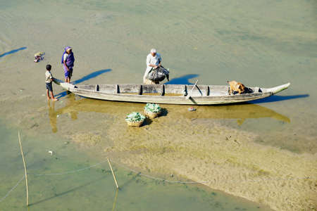 Bandarban, Bangladesh, February 20, 2014 - People load boat with vegetables in Bandarban, Bangladesh.のeditorial素材