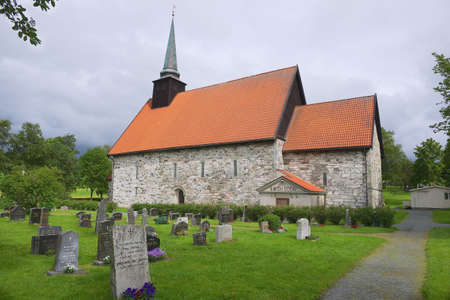 Stiklestadt, Norway - June 25, 2013: Exterior of the medieval Stiklestadt church and cemetery in Stiklestadt, Norway.のeditorial素材