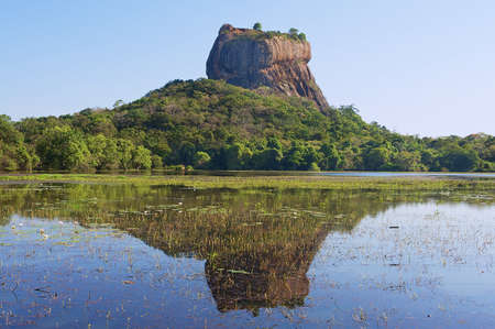 View to the Sigiriya rock fortress with reflection in water in Sigiriya, Sri Lanka. Sigiriya is a UNESCO World Heritage site.の写真素材