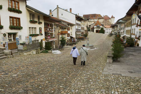 Gruyeres, Switzerland, December 11, 2009 - People walk by the street of the medieval town of Gruyeres, Switzerland.のeditorial素材