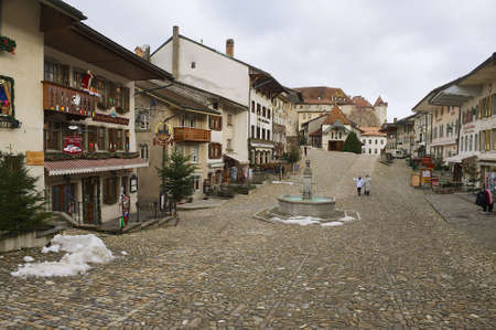 Gruyeres, Switzerland, December 11, 2009 - People walk by the street of the medieval town of Gruyeres, Switzerland.のeditorial素材