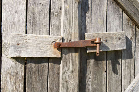 Old rusted metal barn door lock.