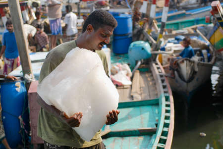 Al Hudaydah, Yemen, September 17, 2006 - Fisherman carries pack of ice in the fishing port in Al Hudaydah, Yemen.のeditorial素材