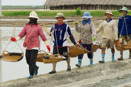 Huahin, Thailand, May 13, 2008 - People work at the salt farm in Huahin, Thailand. Salt production is one of the main industries in the Huahin area, it brings modest income to many local families.のeditorial素材