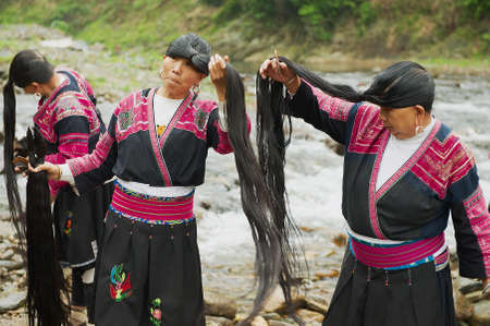 Longji, China, May 06, 2009 - Women brush and style hair in Longji, China. Women of Red Yao people...