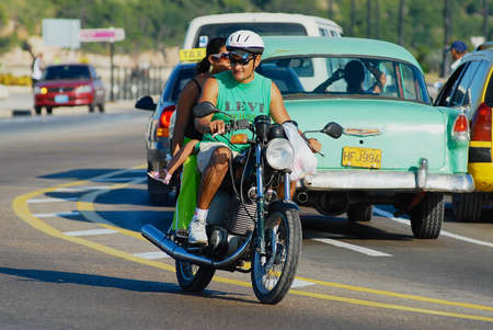 Havana, Cuba, October 21, 2006 - People ride motorbike by Malecon avenue in Havana, Cuba.のeditorial素材