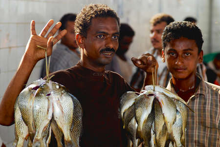 Al Hudaydah, Yemen, September 17, 2006 - Yemeni fisherman demonstrates catch in the market at Al Hudaydah, Yemen.のeditorial素材