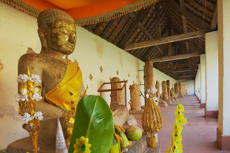 VIENTIANE, LAOS - APRIL 23, 2012; Buddha statue with fresh offerings at That Luang Stupa in Vientiane, Laos.のeditorial素材