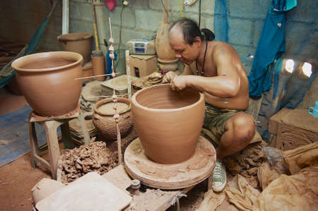 Nakhon Ratchasima, Thailand - April 10, 2010: Man produces traditional clay pottery in a workshop in Nakhon Ratchasima, Thailand.のeditorial素材