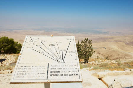 Mount Nebo, Jordan - August 18, 2012: Desert mountain landscape with plaque showing the distance from Mount Nebo, Jordan.のeditorial素材