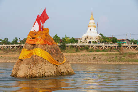 Nong Khai, Thailand - April 15, 2010: Phra Tad Klang Nam sunken cheri collapsed into Mea Khong river in 1847 with the Wat Phra That Chedi at the riverbank in Nong Khai, Thailand.のeditorial素材
