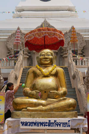 Nong Khai, Thailand - April 15, 2010: Golden Buddha statue in front of the Wat Phra That Chedi in Nong Khai, Thailand.のeditorial素材
