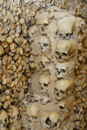 Sives, Portugal - July 18, 2006: Human skulls and bones fixed in the wall of the Chapel of Bones (Capella dos Ossos) at Alcantarilha in Silves, Portugal.のeditorial素材
