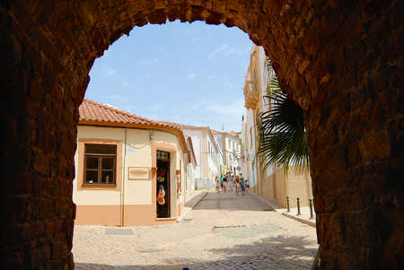 Silves, Portugal - July 18, 2006: View to the street with historical buildings trough an arch in Silves, Portugal.のeditorial素材