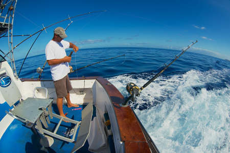 Saint-Denis, Reunion - December 08, 2010: Unidentified sailor gets ready reels and rods for marlin game fishing at sea near Saint-Denis, Reunion island.のeditorial素材