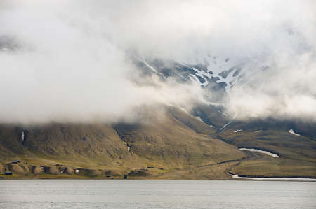 Heavy clouds over the arctic shore of the polar archipelago of Spitsbergen near Longyearbyen, Norway.の写真素材