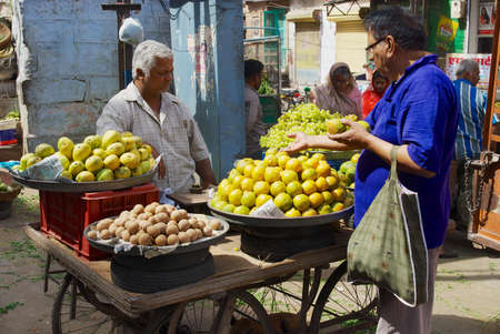 Jodhpur, India - April 06, 2007: Unidentified man buys fruits at the street market in Jodhpur,...