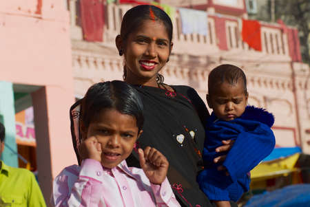 Varanasi, India - March 25, 2007: Portrait of an unidentified lady pilgrim with two kids at the bank of the  Holy Ganges river in Varanasi, India.のeditorial素材