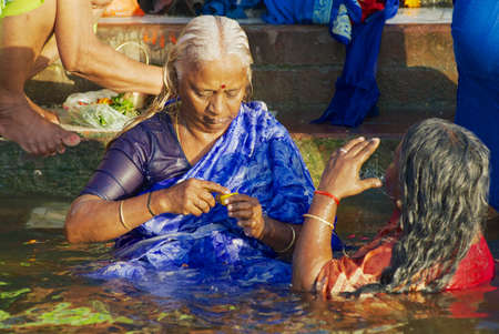 Varanasi, India - March 25, 2007: Unidentified pilgrims bathe in Holy Ganges river at sunrise in Varanasi, India.のeditorial素材