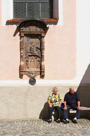 Mittenwald, Germany - September 01, 2010: Unidentified, senior tourists relax at the street next to the cathedral of Mittenwald, Germany.のeditorial素材