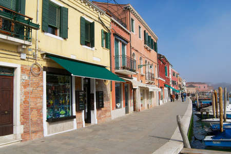 Murano, Italy - February 27, 2007: View to the Grand canal, boats, buildings and people at the street in early spring in Murano, Italy.のeditorial素材