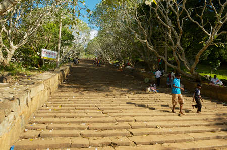 Anuradhapura, Sri Lanka - May 19, 2011: People walk by the ancient stone staircase leading to a Buddhist temple in Anuradhapura, Sri Lanka.のeditorial素材