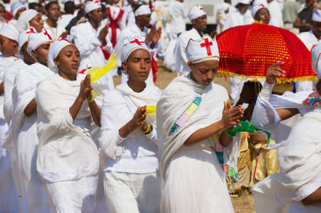 Addis Ababa, Ethiopia - January 19, 2010: Young Ethiopian ladies wearing white dresses take part in procession celebrating Timkat religious Orthodox festival at the street in Addis Ababa, Ethiopia.のeditorial素材