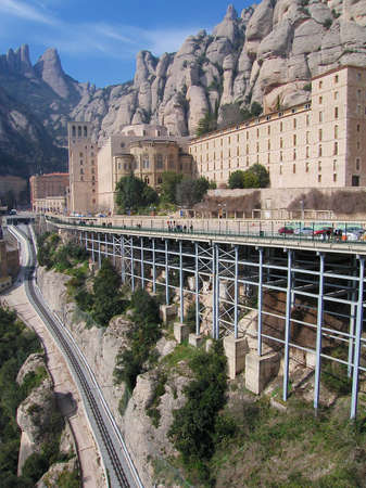 Montserrat, Spain - March 15, 2006: View the famous Benedictine monastery of Montserrat and railway line with cliffs and blue sky at the background in Montserrat, Spain.のeditorial素材