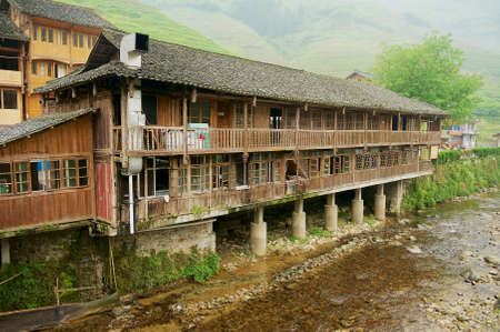 Longsheng, China - May 06, 2009: Traditional wooden buildings at the bank of the river in Longsheng near Guilin in Guanxi, China.のeditorial素材