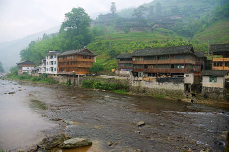 Longsheng, China - May 06, 2009: Traditional wooden buildings at the bank of the river in Longsheng near Guilin in Guanxi, China.のeditorial素材